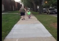 Isä auttaa lastaan pyöräilemään