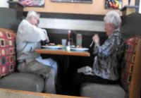 Vanha pariskunta hassuttelee ravintolassa