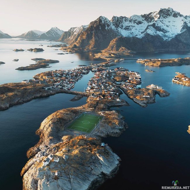 Jalkapallokenttä Norjan lofooteilla - Norjassa, Henningsværissa jalkapallokenttä pistää silmään saaristolaiskaupungin maisemassa