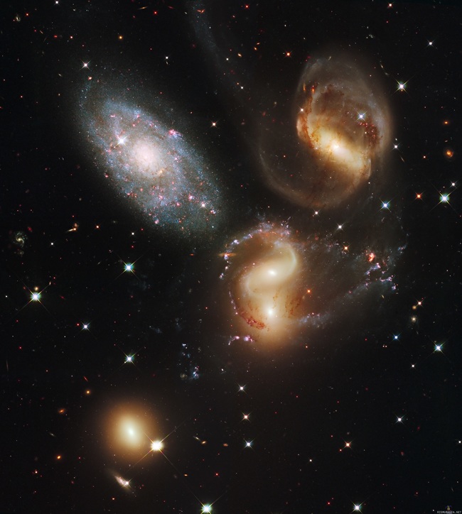 Stephan&#039;s Quintet - Stephanin kvintetti on Pegasuksen tähdistössä sijaitseva viiden galaksin joukko, ja yksi eniten tutkituista tiiviistä galaksiröykkiöistä. Kuvan neljä punertavaa galaksia (joista kaksi ovat törmänneet toisiinsa) sijaitsevat noin 290 miljoonan valovuoden päässä, kun taas sinertävä galaksi NGC7320 (kuvassa ylävasemmalla) sijaitsee &quot;vain&quot; 40 miljoonan valovuoden päässä, siis yli 7 kertaa lähempänä. Taustan galaksit ovat siis melkein 7 kertaa suurempia kuin etualan NGC7320. Huhhuh.