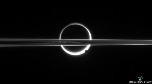 Titan, Enceladus ja Saturnuksen renkaita - Kuvan ilmiö ei ole auringonpimennys. Auringonvalo saa Saturnuksen kuun, Titanin kaasukehän hehkumaan, ja kuvassa näkyvä tumma keskusta on kuun kiinteä osa. Nykytiedon mukaan kaasukehä koostuu lähinnä typestä ja metaanista. Sen edessä näkyvät Enceladus-kuu ja osa Saturnuksen renkaista.

Kuva on otettu Saturnusta kiertävällä Cassini-luotaimella, jonka tehtävä jatkuu näillä näkymin 2017 asti.

Credit: Cassini Imaging Team, SSI, JPL, ESA, NASA