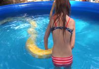 Tyttö uimassa pythonin kanssa